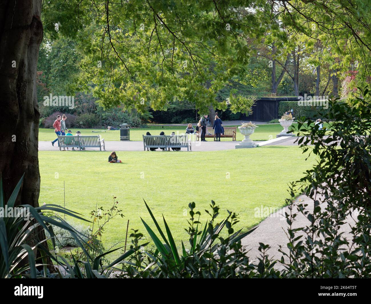 People relaxing in Queen Mary's Gardens within the inner circle of London's Regent's Park Stock Photo