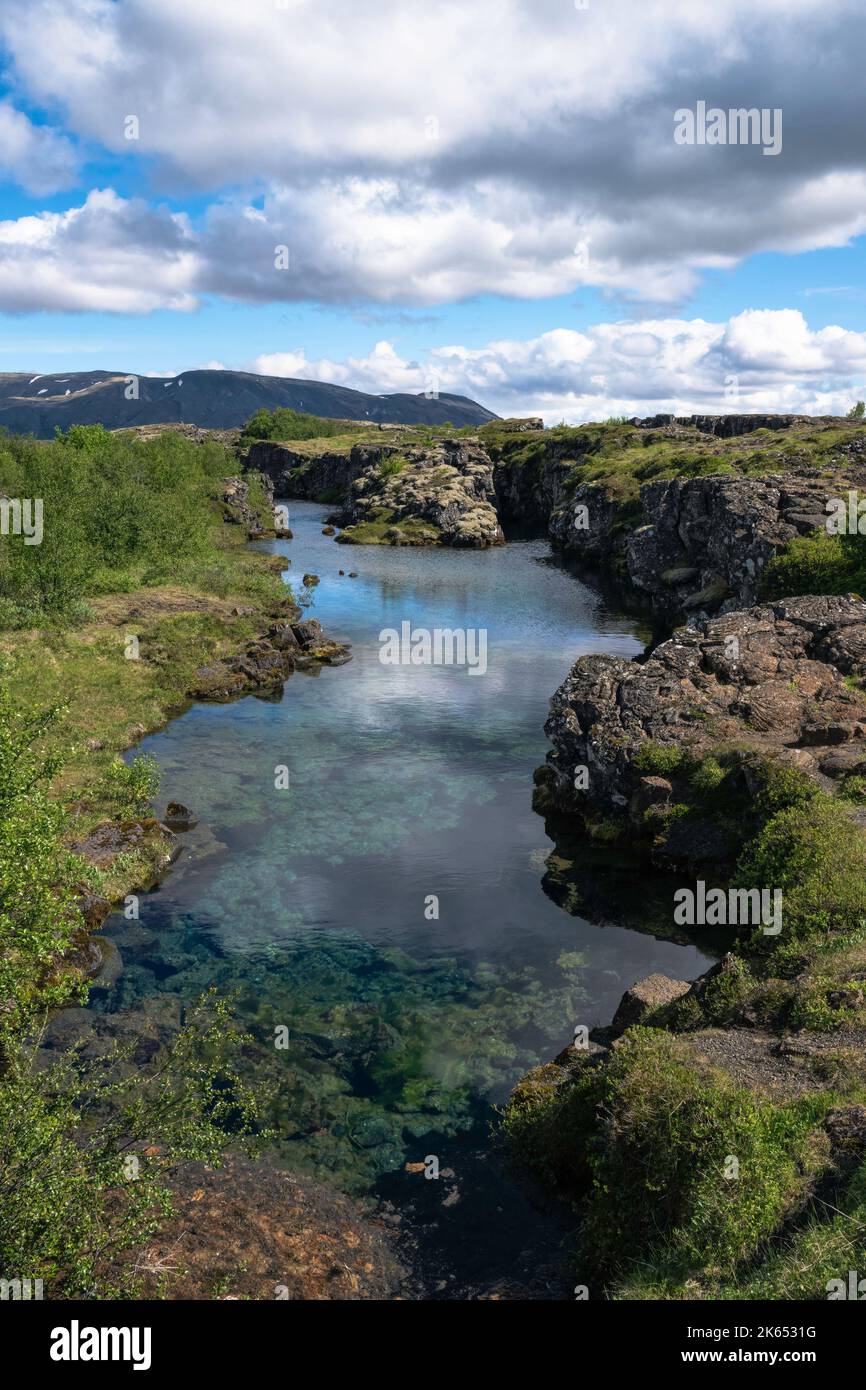 Clouds reflected in glacial water filling a fissure between tectonic plates in Thingvellir National Park, Iceland Stock Photo