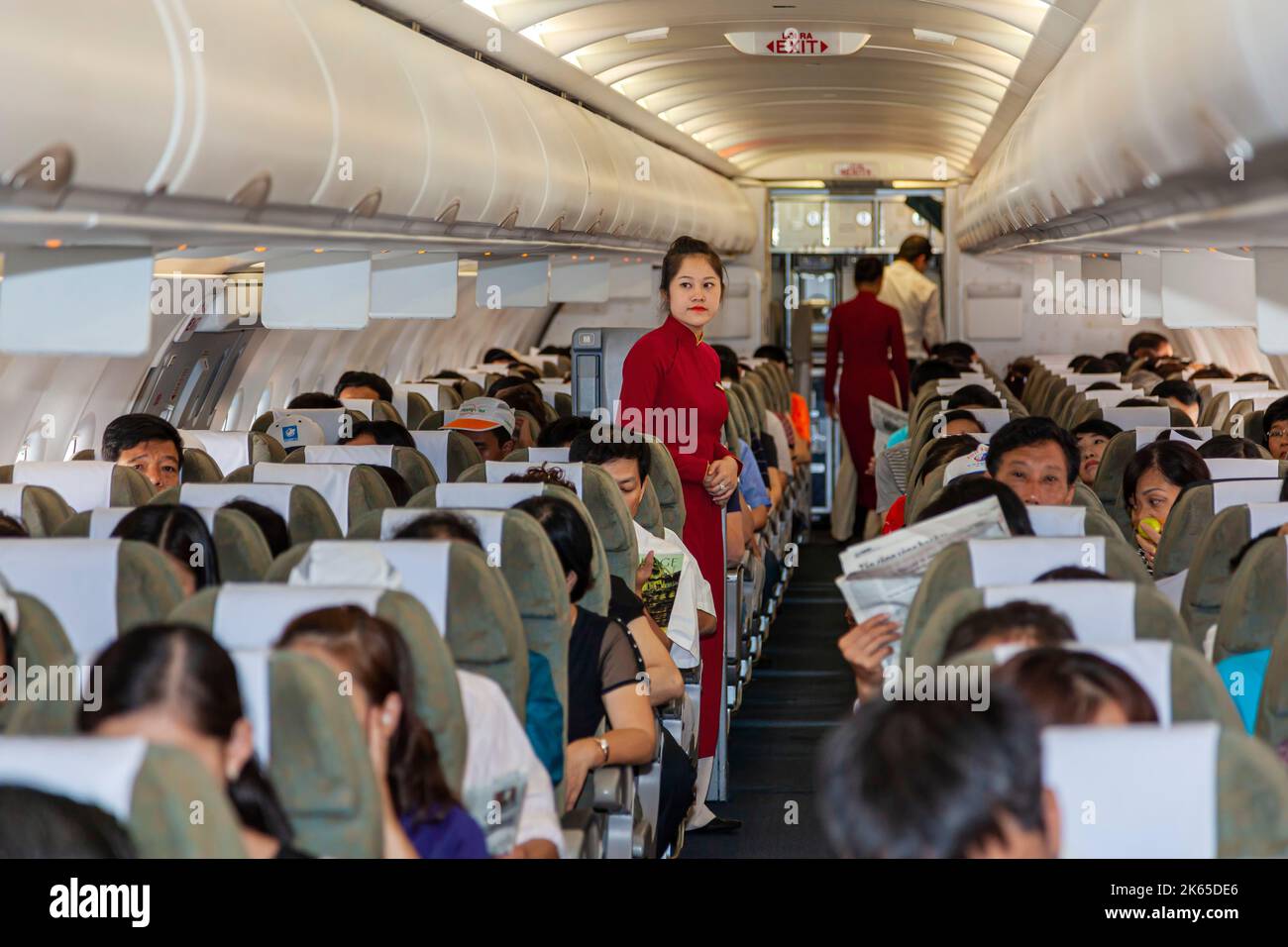 Flight crew and passengers on board Vietnam Airlines flight from Hanoi to Bangkok Stock Photo