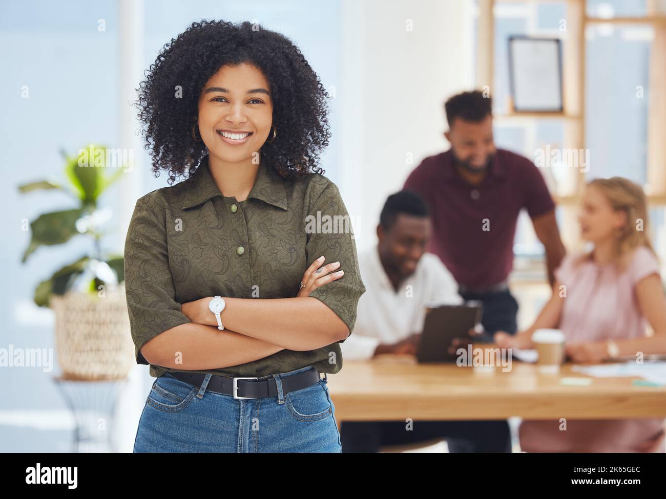 Black woman, leader and crossed arms in office, workplace and happy group project, startup company or confident. Proud female, lady worker or smile Stock Photo