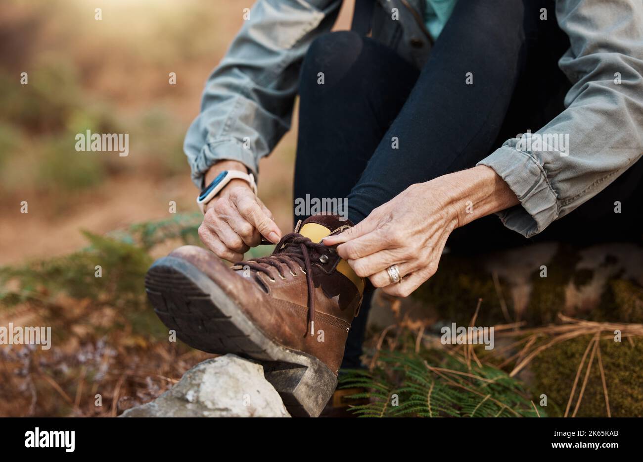 Put on your boots and go for a hike. a woman tying her shoelaces while