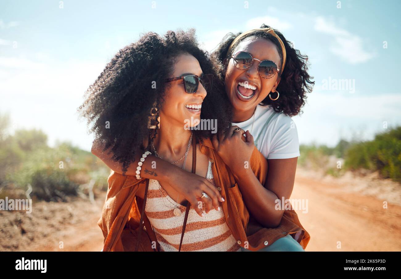 Black women, friends and nature holiday portrait, vacation or summer trip. Safari, sunglasses and girls piggy back, spending time together bonding and Stock Photo