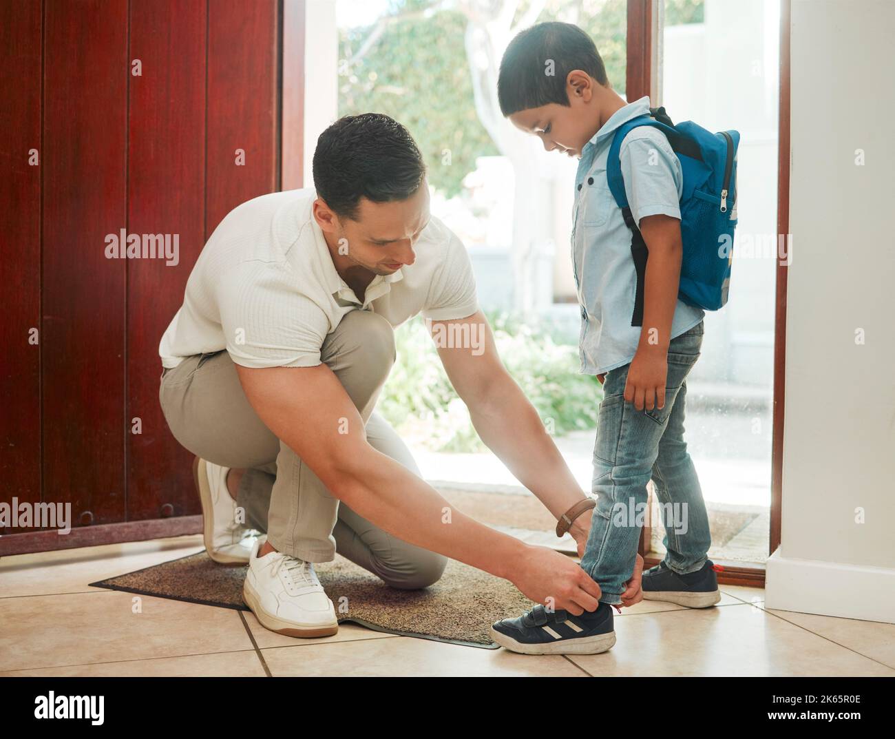 Father and son adjusting shoes at home, getting ready for first day of