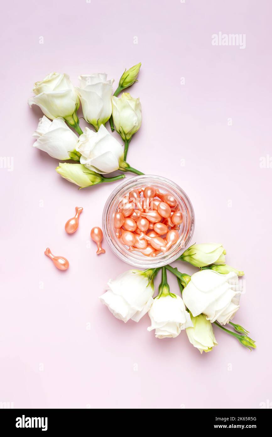 face care oil capsules on pink background. single use nourishing oil for dry and damaged skin. antiage therapy. daily beauty routine. Pink background Stock Photo