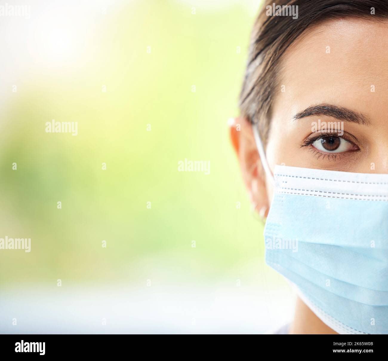 Portrait of a hispanic woman wearing a mask and looking serious in a hospital office Stock Photo