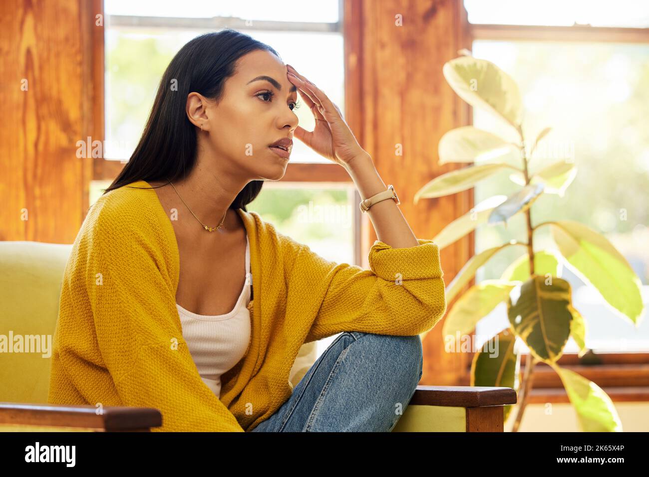 Sad, depressed and thinking woman with mental health problems and anxiety in home. Latino female in depression, stress and fear feeling frustrated Stock Photo