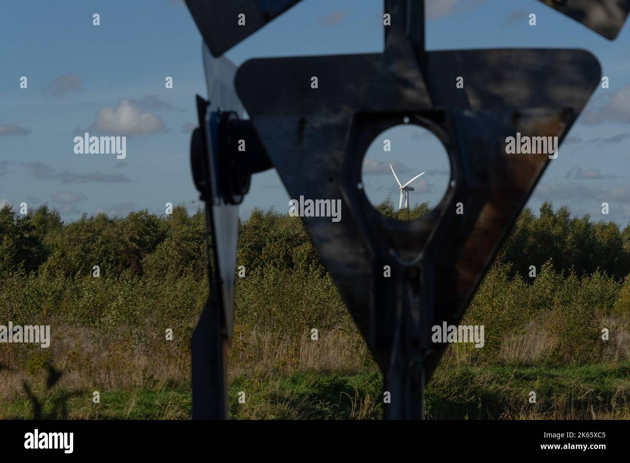 Wind turbine seen through an opening in an old railroad sign Stock Photo
