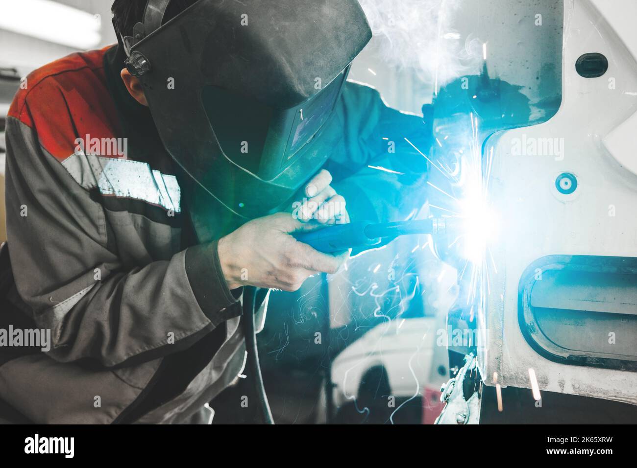 Body shop worker welding car body. Work with carbon dioxide weld