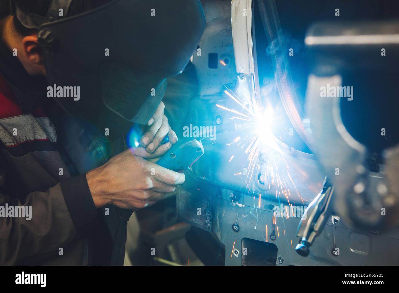 Professional car body repair, welding of auto body. Industrial worker