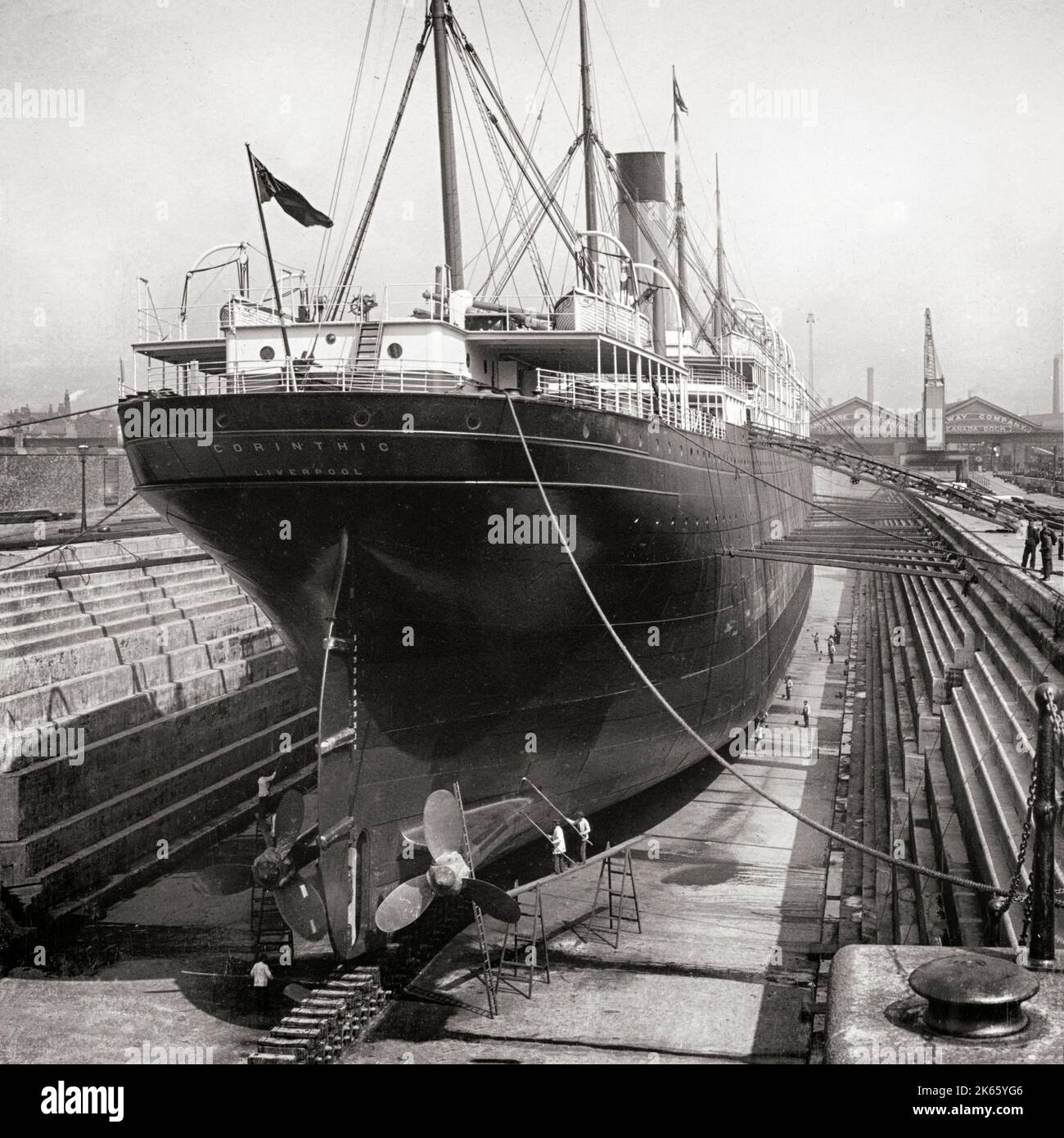 An early 20th century view of the 'Corinthian' in the dry dock (then the world's largest dry dock) next to the Albert dock on the  Liverpool waterfront, England. Built as a cargo and passenger liner for the White Star Line and Shaw, Savill & Albion Lin,e she was launched in 1902 from Harland and Wolff in Belfast. Stock Photo