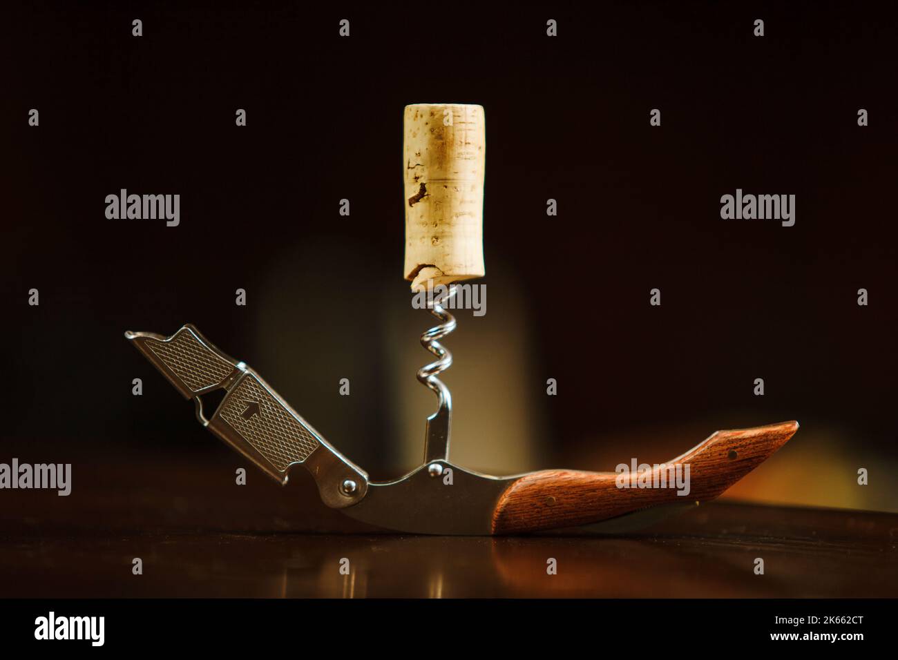 Wooden cork in a corkscrew lies on table. Bottle opener Stock Photo