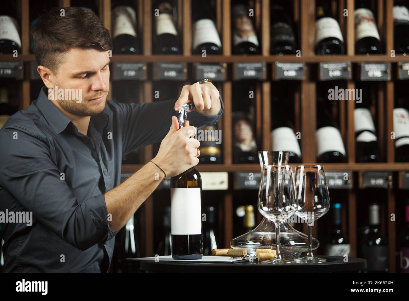 Sommelier opening red wine bottle with corckcrew Stock Photo