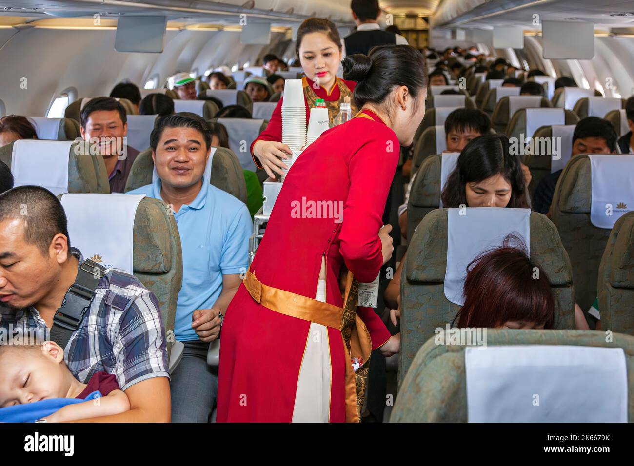 Flight crew and passengers on board Vietnam Airlines flight from Hanoi to Bangkok Stock Photo