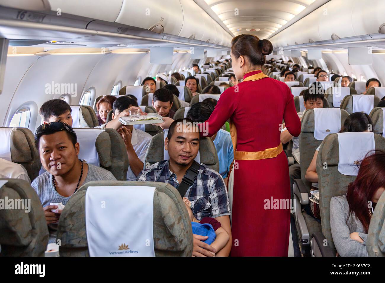 Flight crew and passengers on board Vietnam Airlines flight from Hanoi to Bangkok Stock Photo