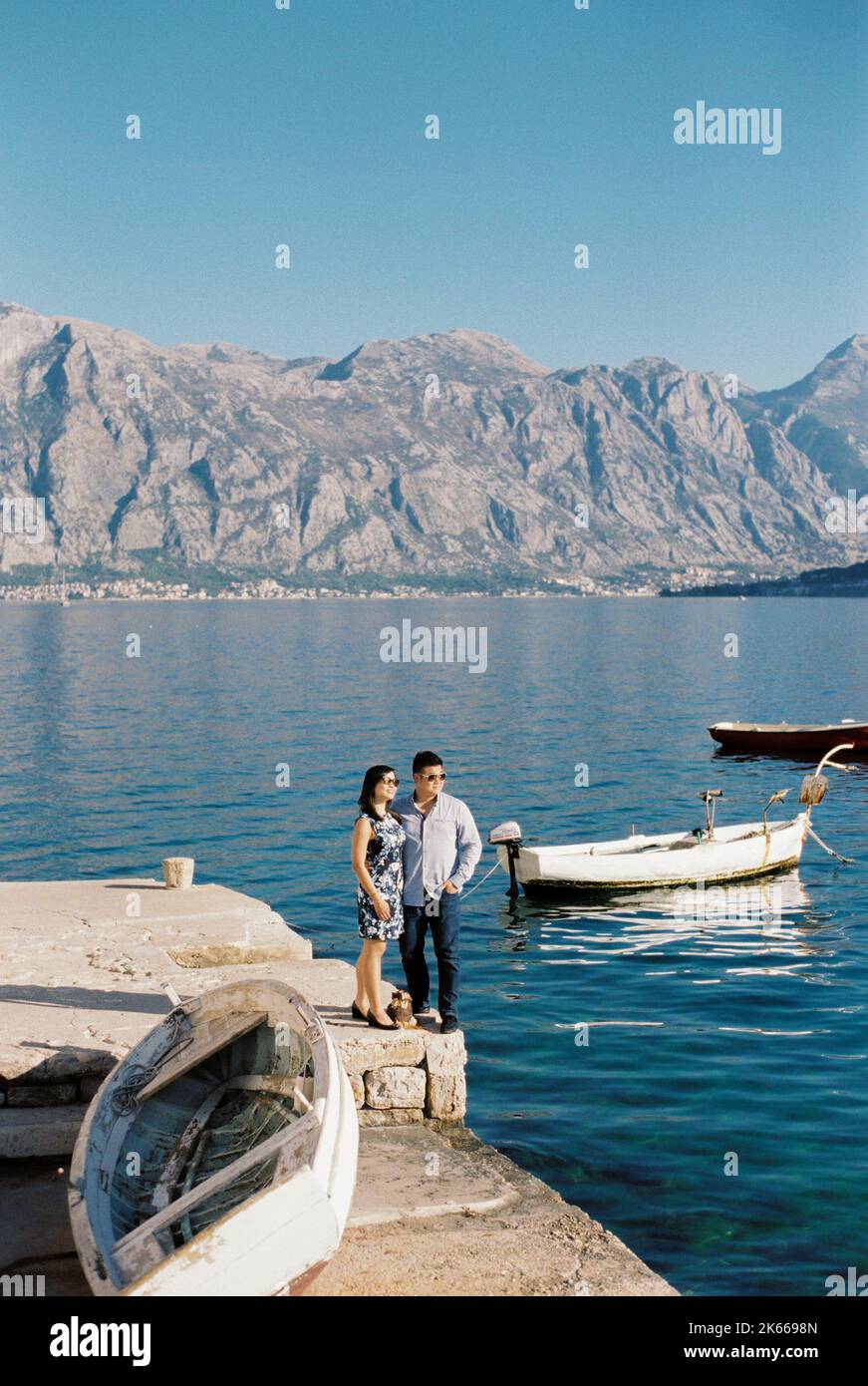 Man and woman stand hugging on the pier and look at the sea Stock Photo ...