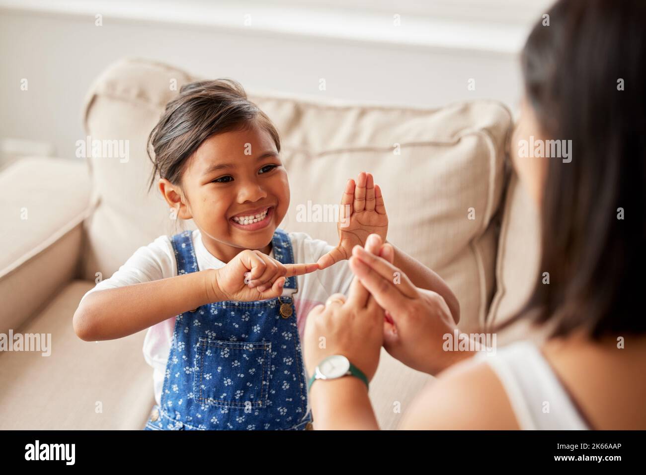 Cute child using sign language to communicate and talk with her mother at home Stock Photo Alamy