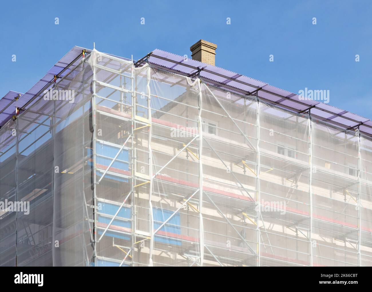 Scaffolding on house facade (with netting), apartment builing under construction Stock Photo