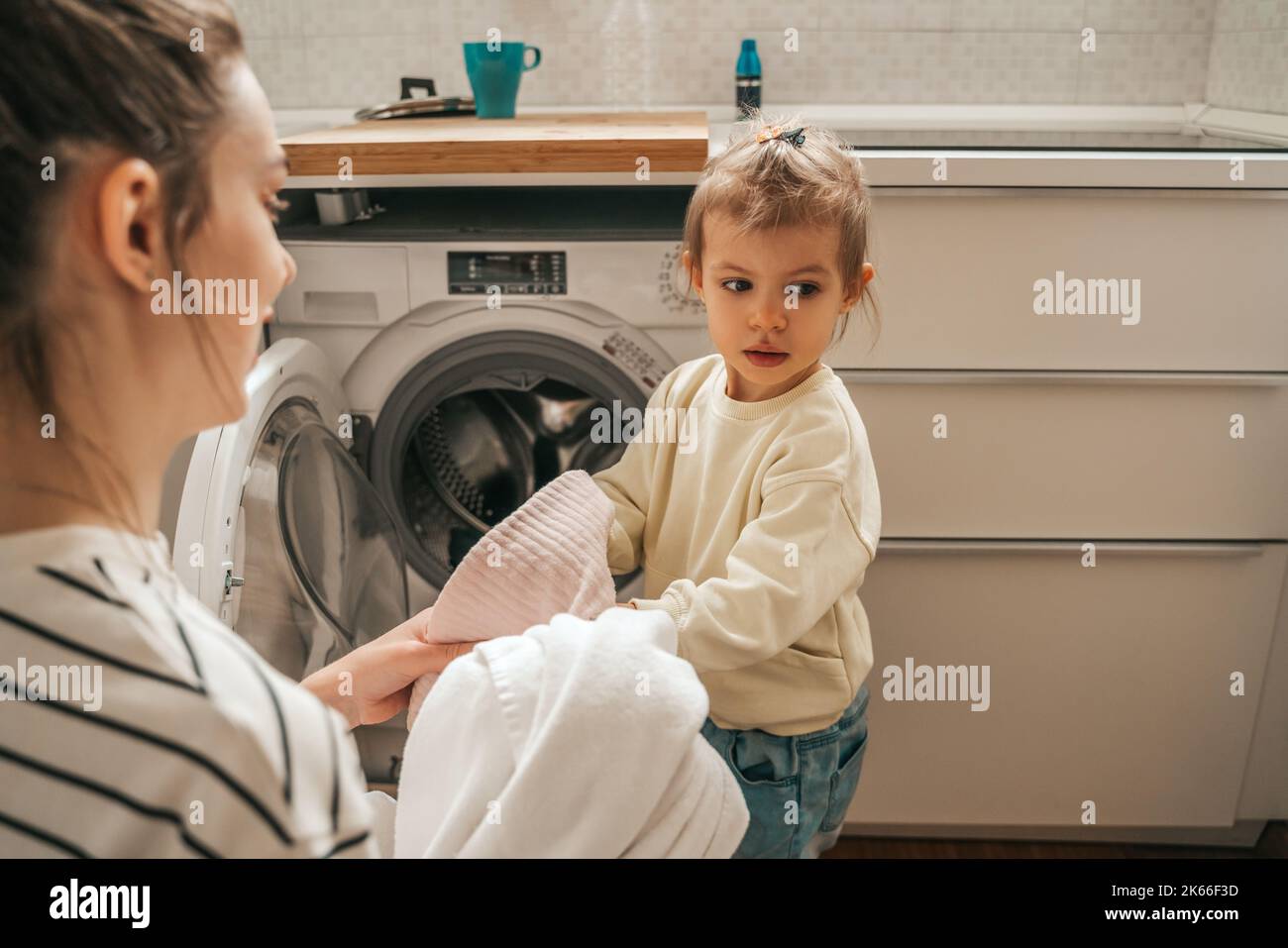 Family of two loading dirty clothes into the washer Stock Photo Alamy