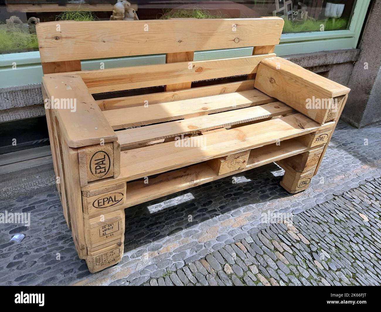 bench made from pallets in front of a downtown store, Germany Stock Photo