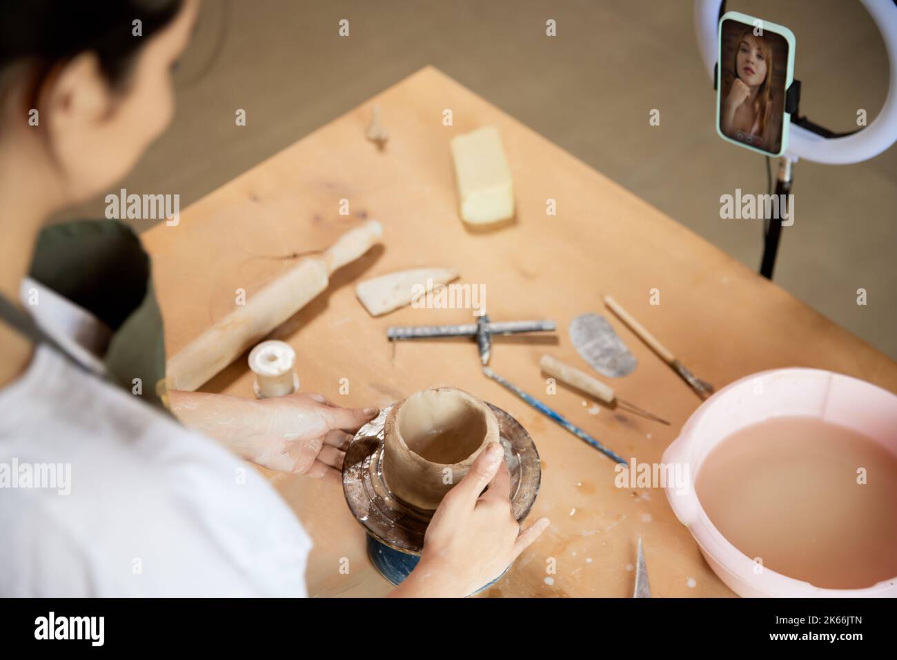 Young girl, pottery master with teaching student to make ceramic
