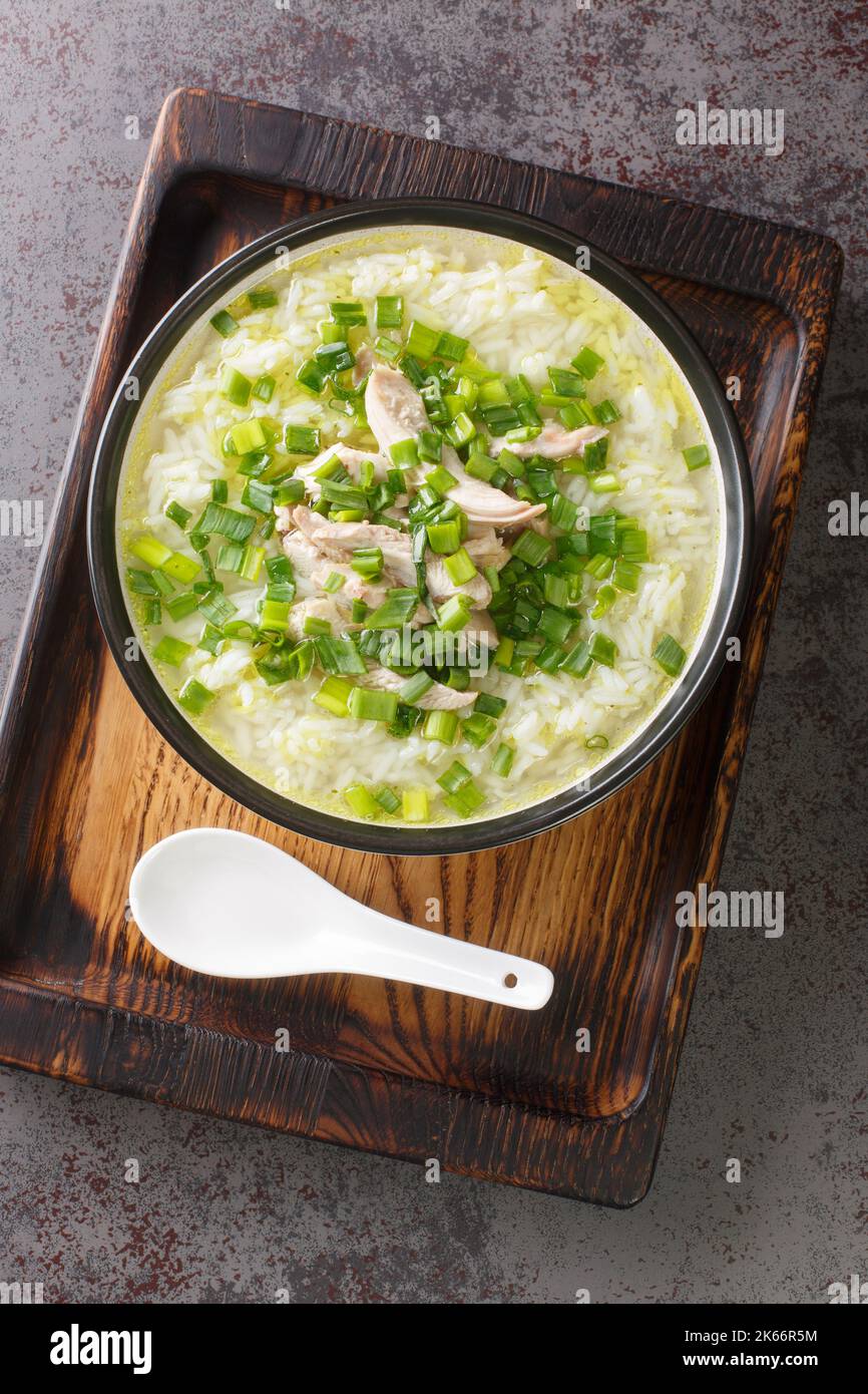Korean chicken soup dak Gomtang is made from long simmered bones and aromatics close-up in a bowl on the table. Vertical top view from above Stock Photo