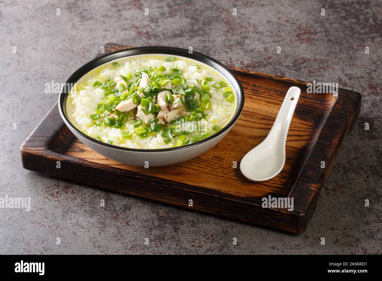 Spicy hot Korean chicken soup with rice and green onions closeup in a