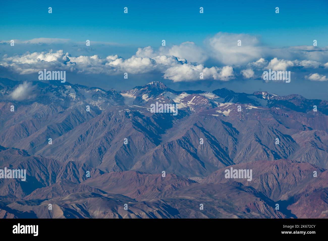 Aerial beautiful scenery of snow-covered landscape of Andes Mountains (Cordillera de los Andes) viewed from an airplane window, near Santiago, Chile. Stock Photo