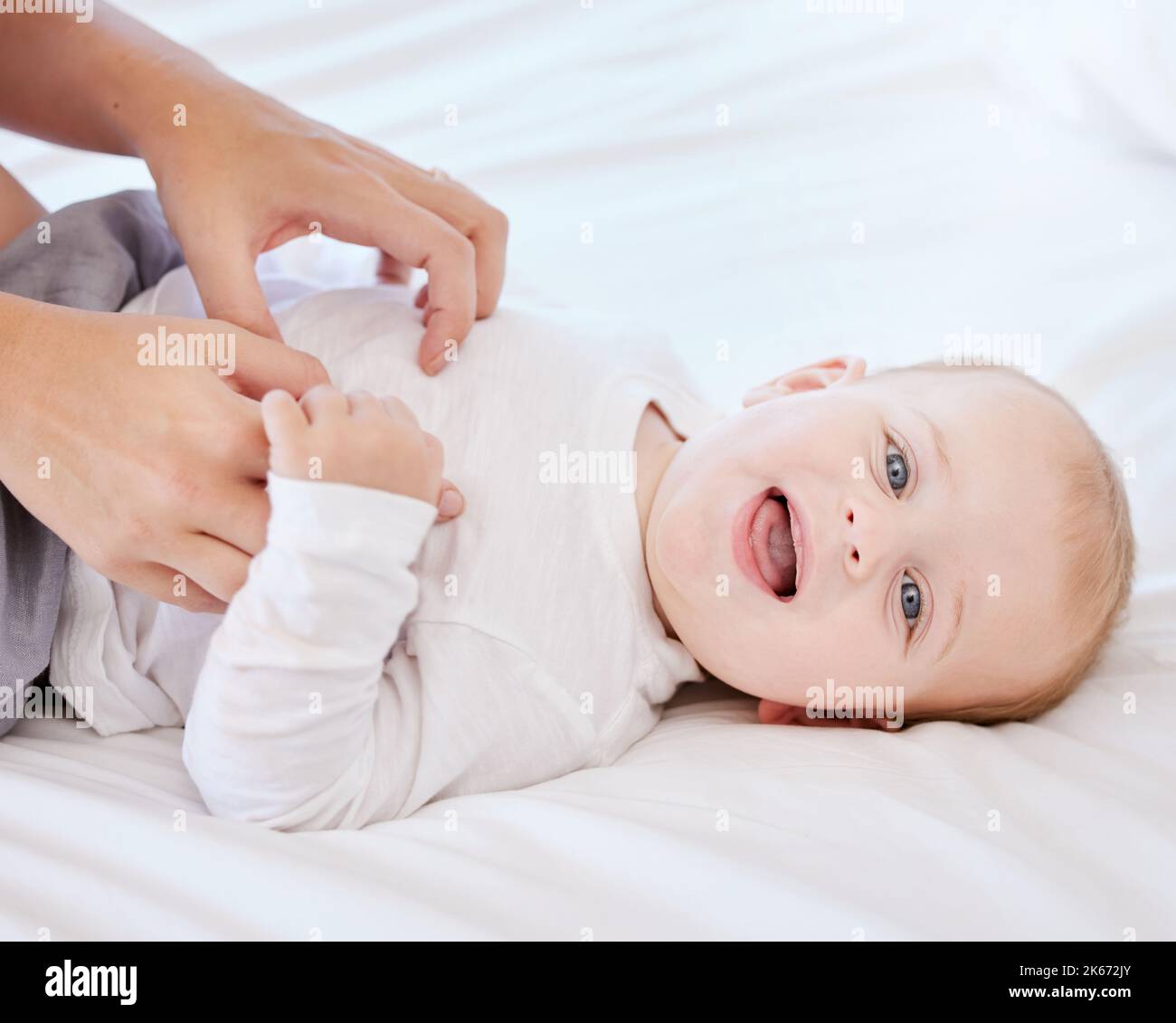 A face that shows only whats real. an adorable little baby boy and his mother playing on a bed at home. Stock Photo