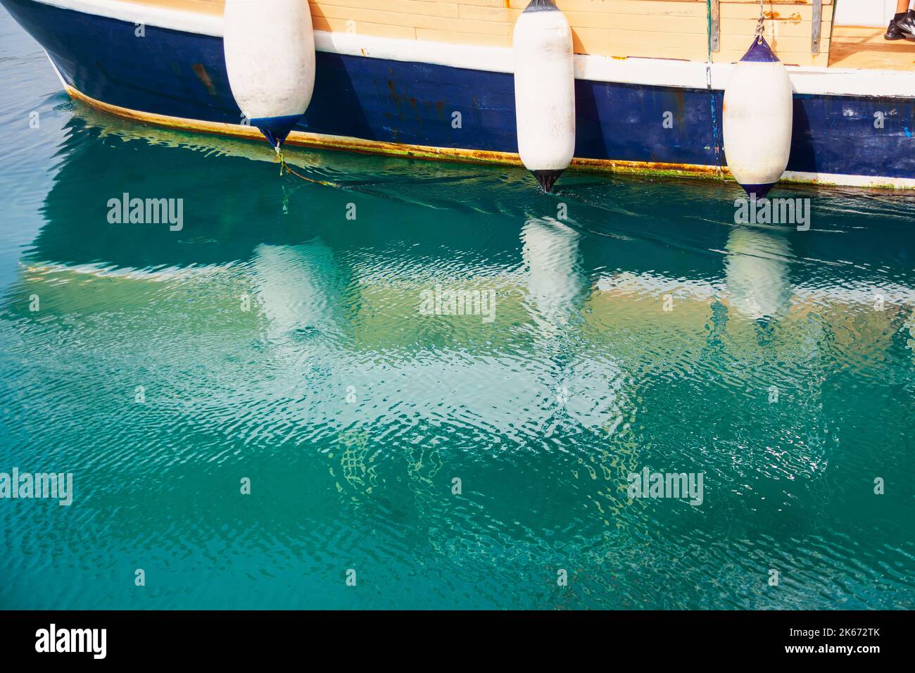 Boat with bumpers . Nautical vessel reflected in the sea water Stock Photo