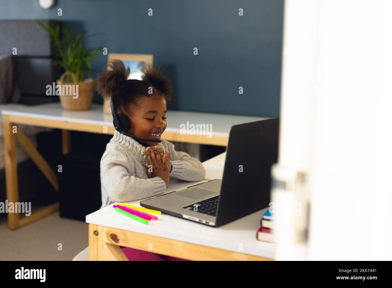 Happy african american girl learning, using laptop and headphone at ...