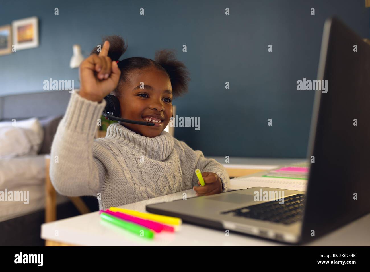 Happy african american girl learning, using laptop and headphone at ...