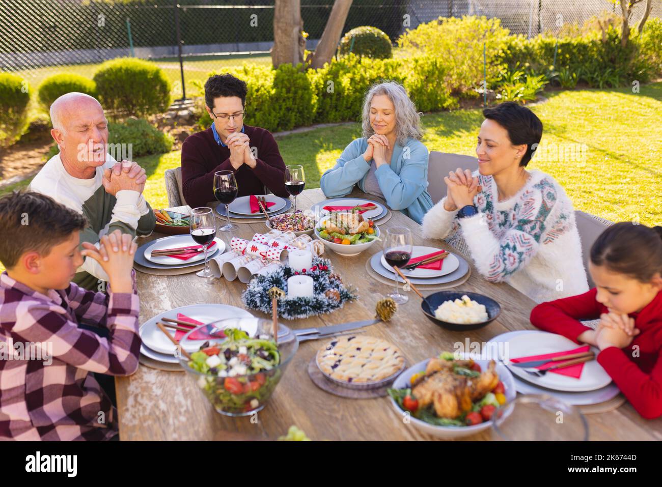 Caucasian family spending time together outside and praying before meal Stock Photo