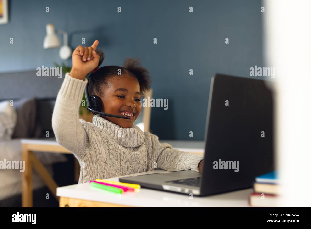 Happy african american girl learning, using laptop and headphone at ...