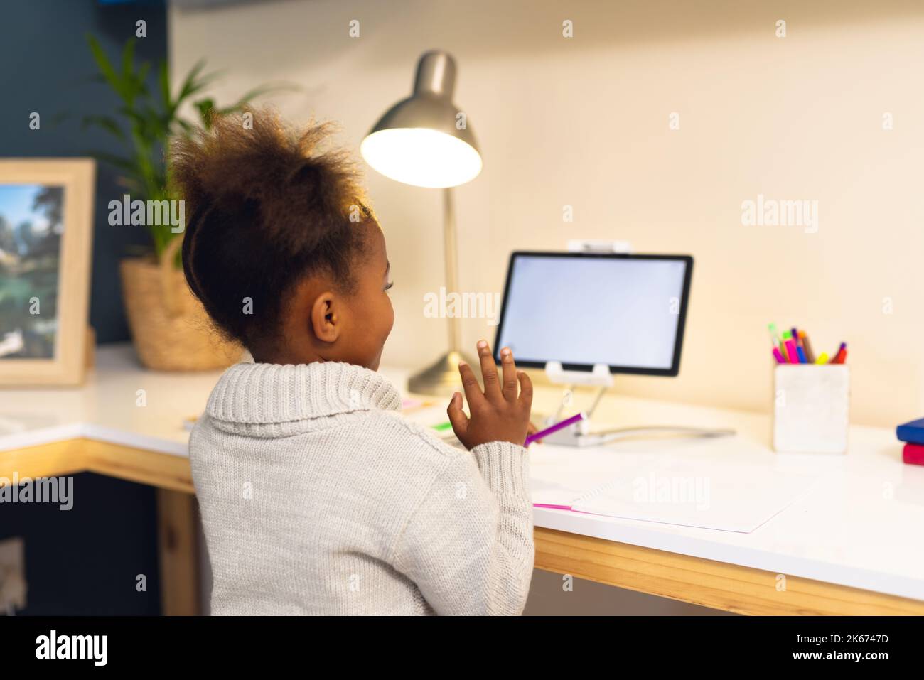 Happy african american girl learning, using tablet with copy at home Stock Photo