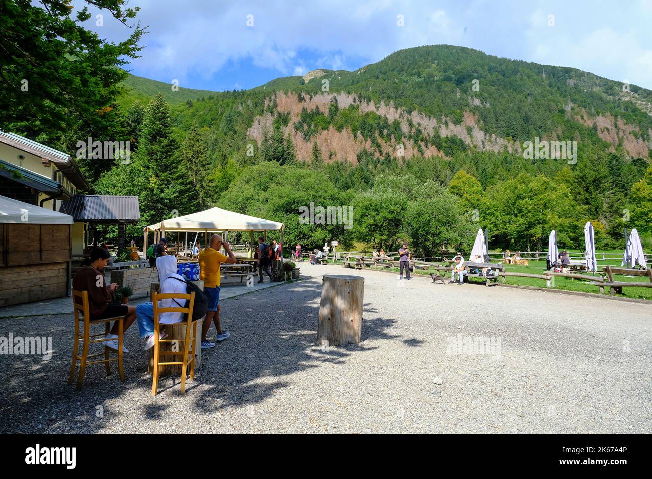 Shelter in the mountains with tourists across parked motorcycles. National park Appennino Tosco-Emiliano, Lagdei, Emilia-Romagna Stock Photo