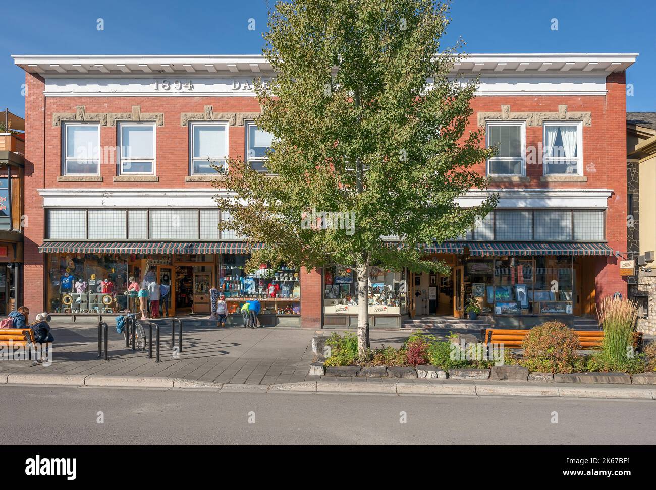 Banff, Alberta, Canada – October 07, 2022:  People gather outside a historic building on Banff Avenue Stock Photo