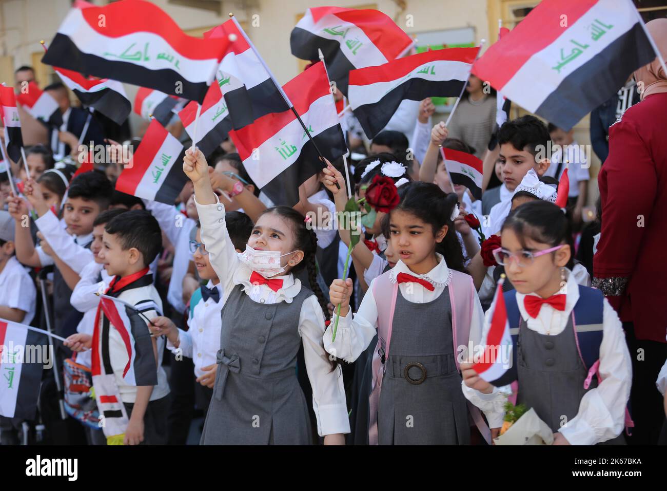 Baghdad, Iraq. 12th Oct, 2022. Students wave national flags on the ...