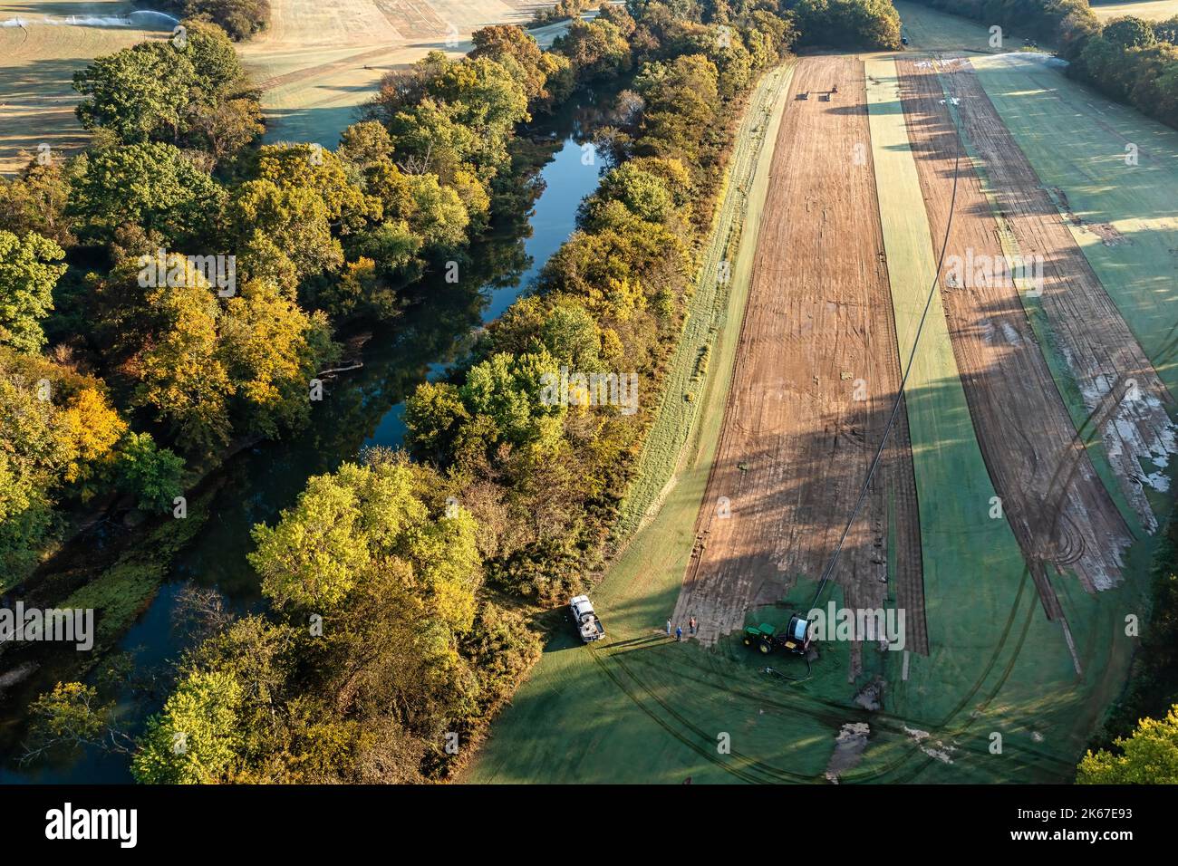 Aerial view of a turf farm with workers irrigating the sod for lawns