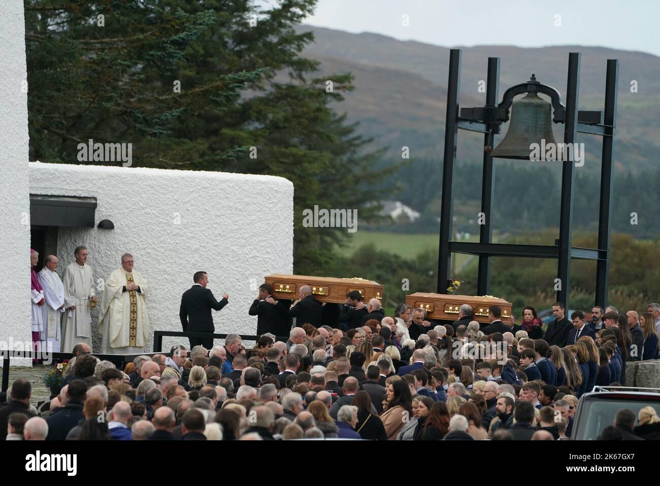 The coffins of James Monaghan and his mother Catherine O'Donnell are carried into St Michael's Church, Creeslough for their funeral mass. They both died following an explosion at Applegreen service station in the village of Creeslough in Co Donegal on Friday. Picture date: Wednesday October 12, 2022. Stock Photo