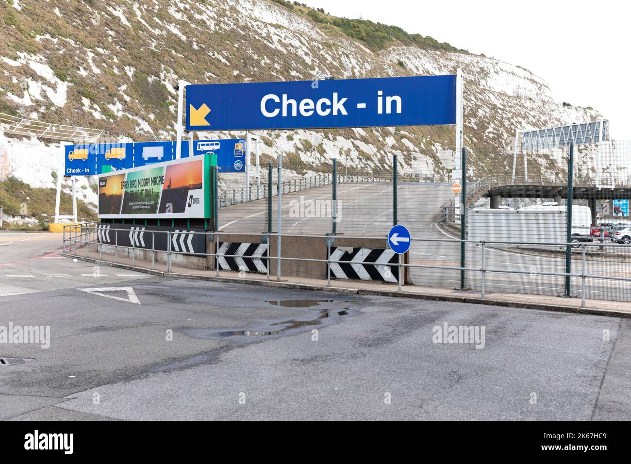 A large check-in sign on an empty entry lane at Port of Dover, Kent, UK. Behind is a close view of the white cliffs of Dover. September 7th, 2022. Stock Photo