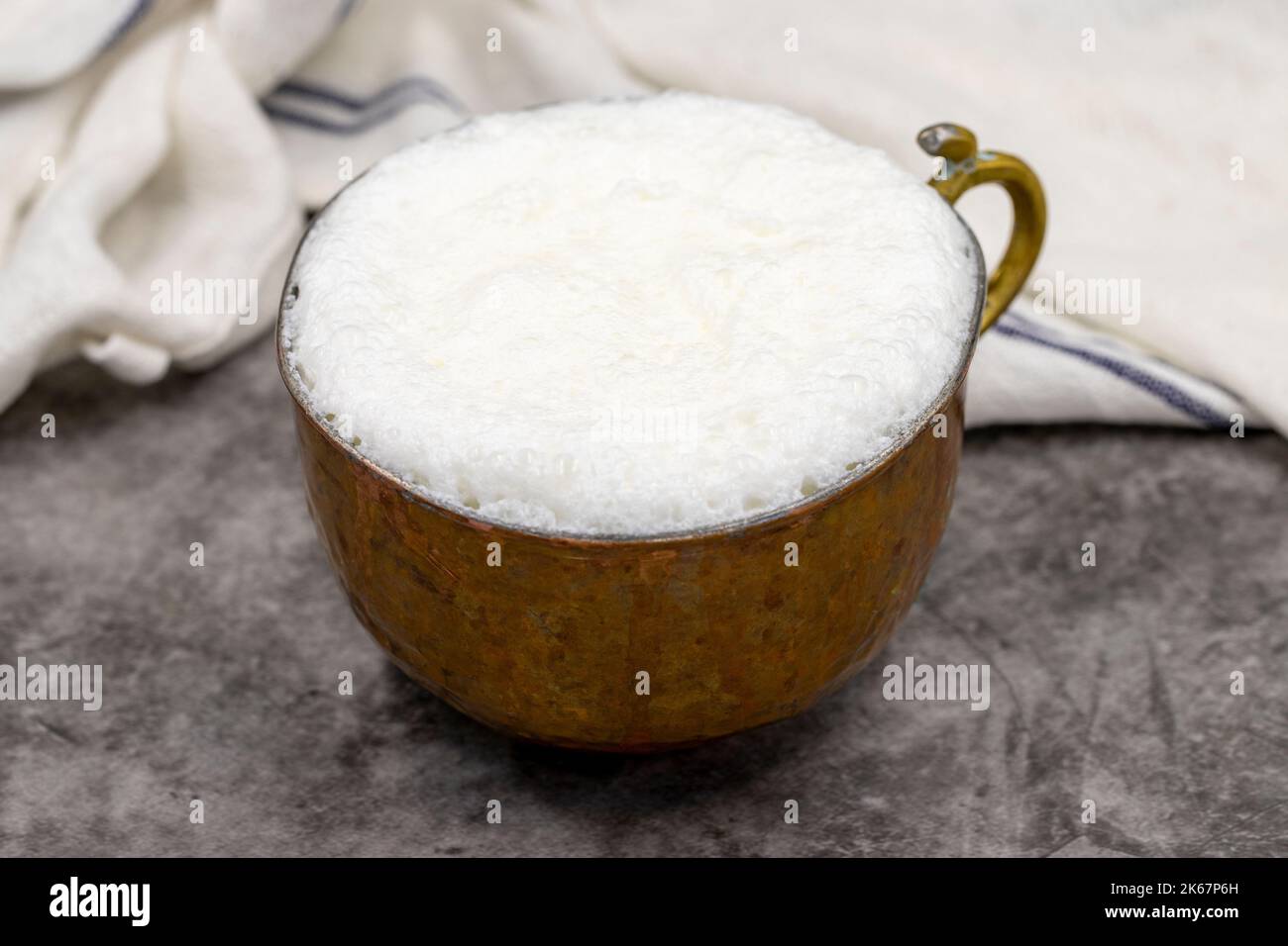 Sparkling buttermilk in a copper glass. Traditional Turkish food. Drink made with yogurt. close