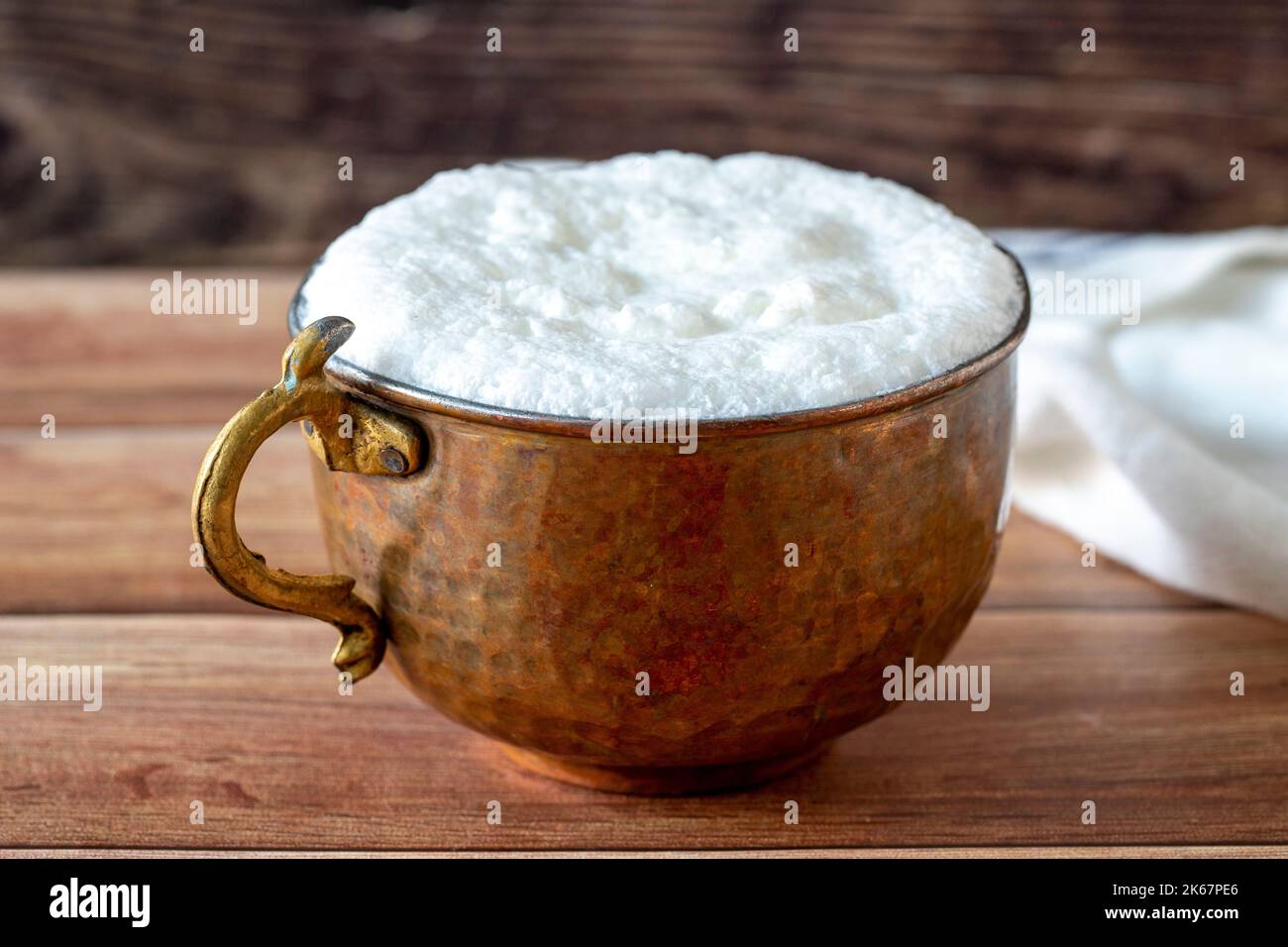 Sparkling buttermilk in a copper glass. Traditional Turkish food. Drink made with yogurt. close