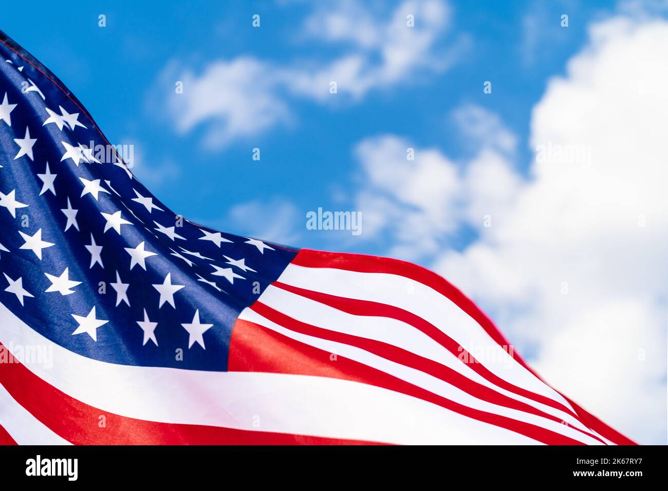 American flag on flagpole waving in the wind against white clouds Stock ...