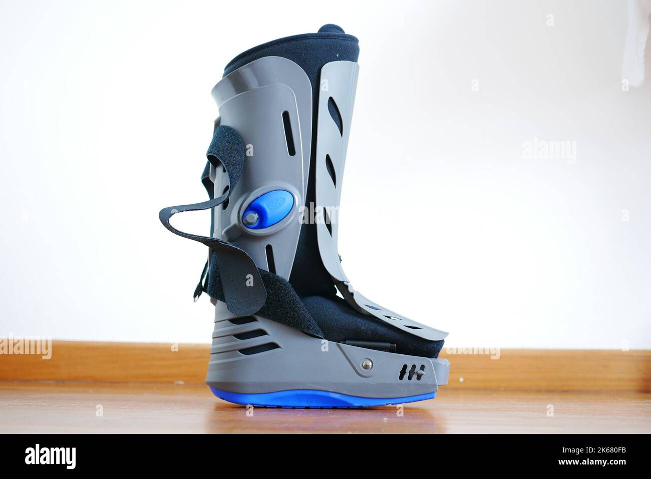 a grey plastic boot ankle brace injury protecting boot against white wall Stock Photo Alamy