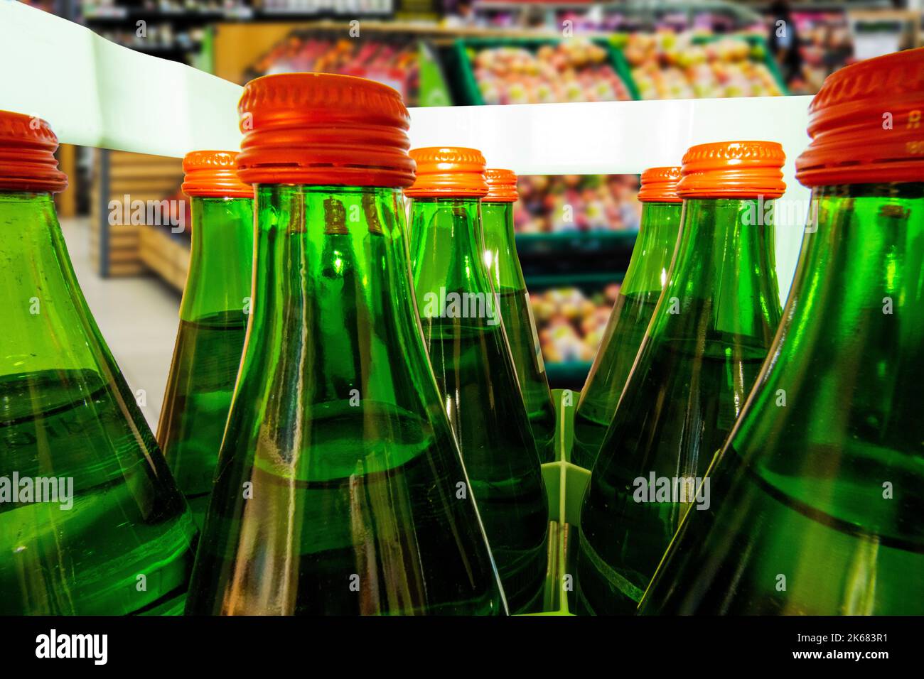 Nahaufnahme von einer Kiste Mineralwasser mit grünen Mehrweg-Glasflaschen Stock Photo