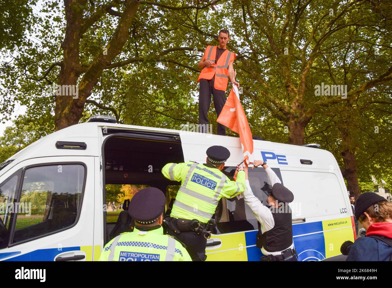 London, UK. 12th October 2022. A Just Stop Oil activist climbs on top of a police van outside Downing Street on Horse Guards Road, as the climate action group continues its daily protests demanding that the UK Government stops issuing new oil and gas licences. Credit: Vuk Valcic/Alamy Live News Stock Photo