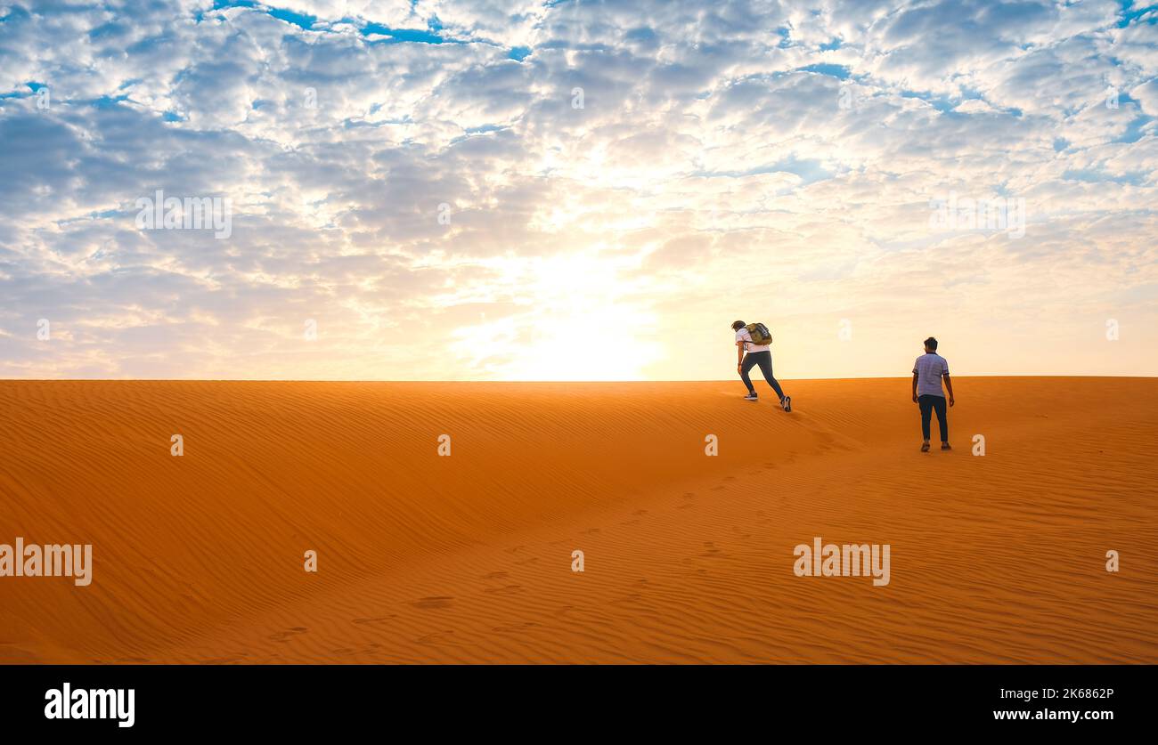 People climbing sand dune in the desert Stock Photo Alamy