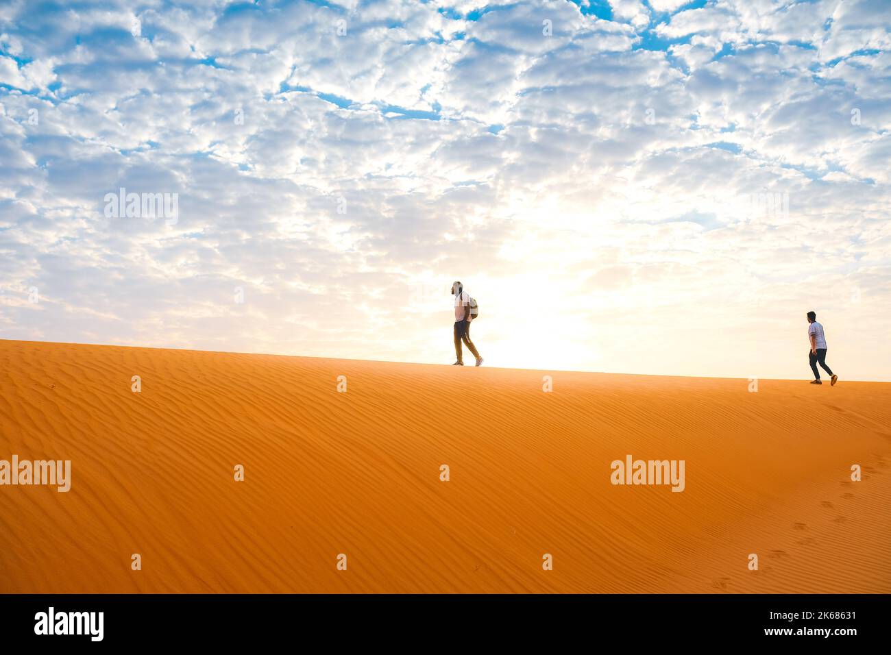 People standing on top of a sand dune at sunrise Stock Photo - Alamy