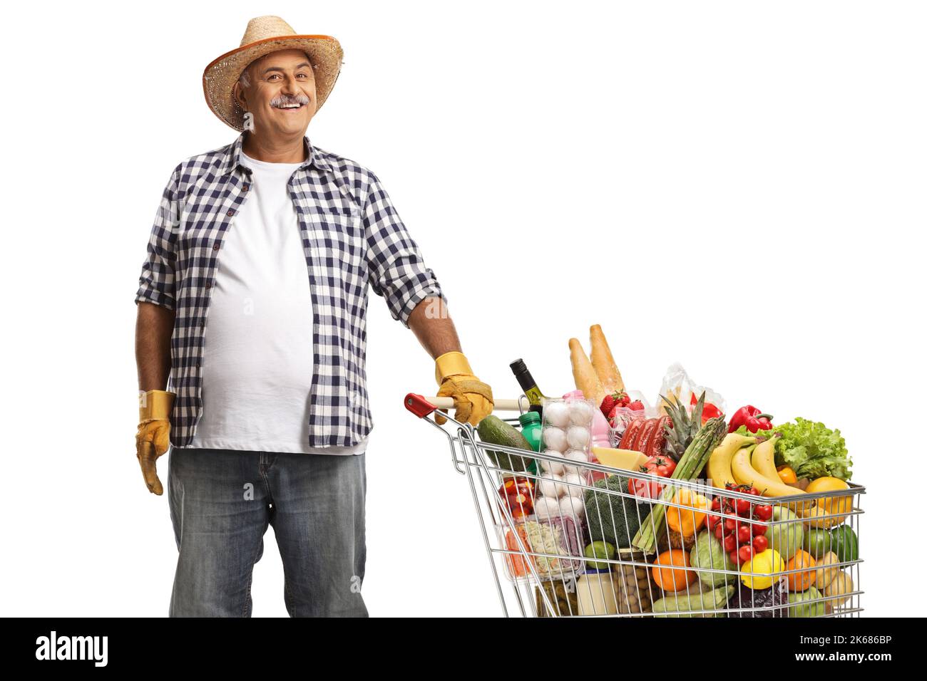 Mature farmer posing with a shopping cart full of food products isolated on white background Stock Photo