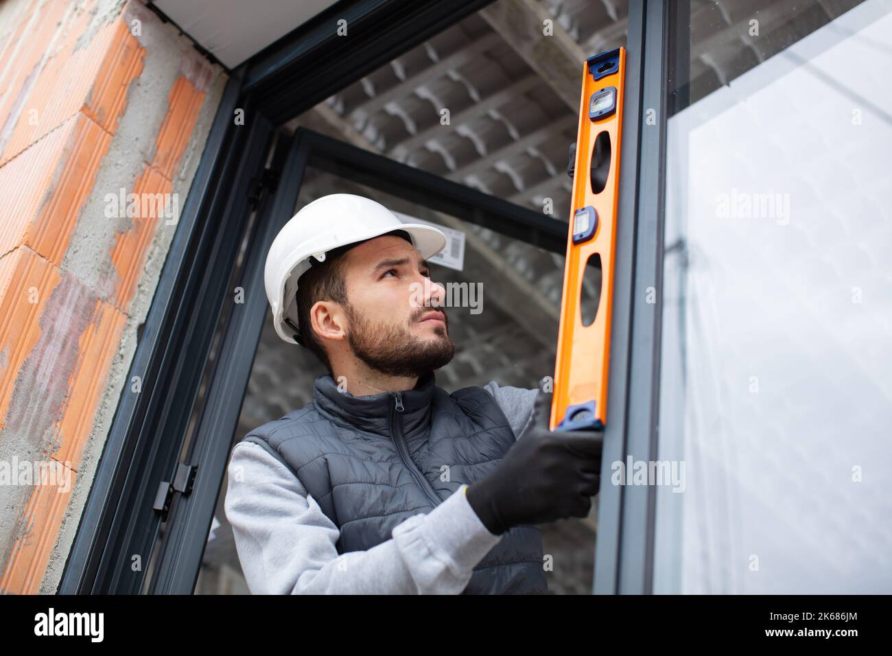workman in uniform mounting windows checking their level Stock Photo